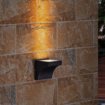 Close-up view of bronze outdoor light fixture showing curved arm and mounting details