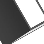 Vertical LED wall sconce mounted on textured stone exterior creating ambient lighting