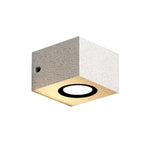 Square concrete wall light with warm LED creating subtle ambient lighting on neutral background