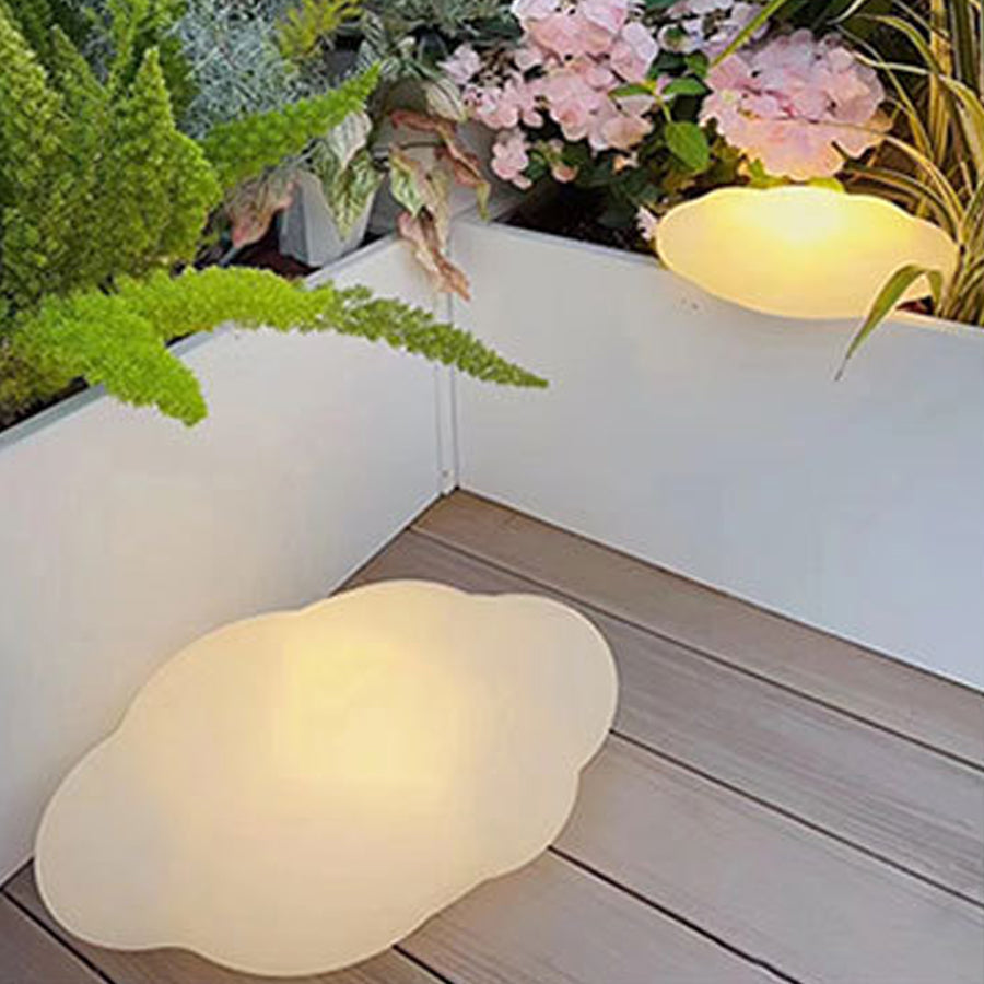 Organic white LED light fixture with smooth curves positioned on wooden deck surface