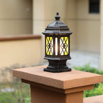 Traditional lantern-style post cap light with diamond lattice glass pattern mounted on wooden fence post