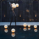 Contemporary orb lights suspended from modern architectural structure creating dramatic evening atmosphere