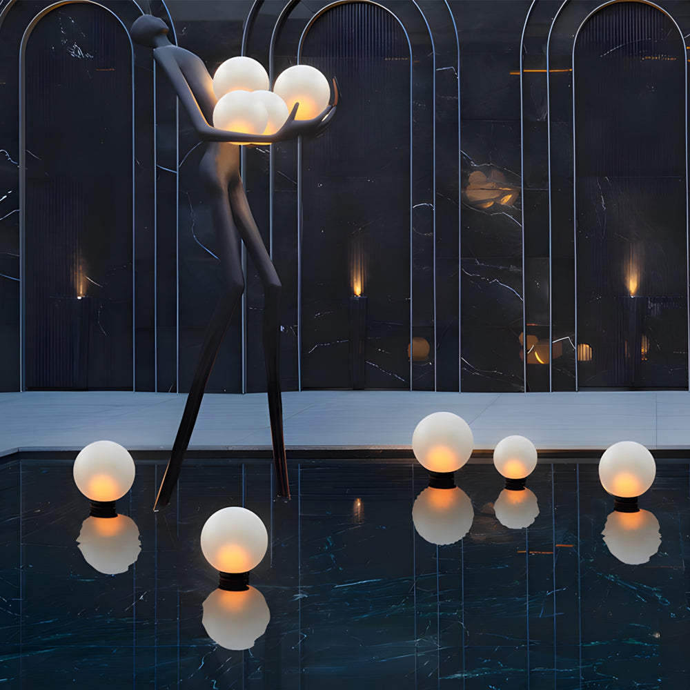 Contemporary orb lights suspended from modern architectural structure creating dramatic evening atmosphere