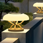 Modern circular bollard light with dome top and cylindrical base creating gentle ambient illumination for landscapes