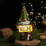 Welcome gnome with illuminated sign and warm LED lighting for evening garden ambiance