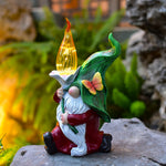 Fantasy gnome with flame hat and illuminated features positioned on stone garden surface