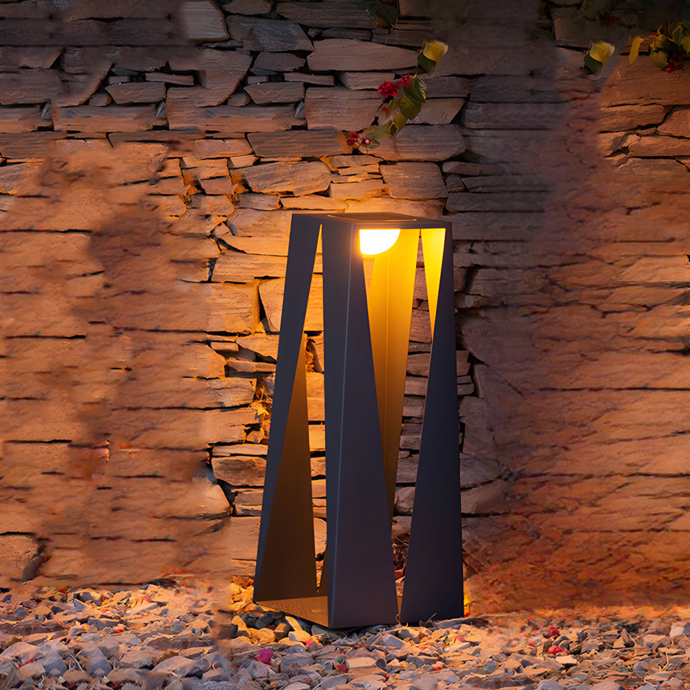 Sculptural outdoor lighting fixture illuminating textured brick wall in evening setting