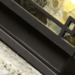 Pagoda-style outdoor lantern photographed in natural garden setting with stone base