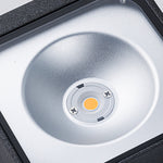 Close-up view of bronze outdoor light fixture showing curved arm and mounting details