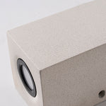 Close-up detail of square concrete outdoor wall light with circular LED opening and modern design