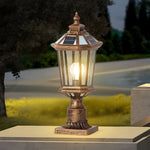 Classic pillar light casting warm illumination on stone patio surface with traditional lantern design elements