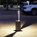 Contemporary bollard lighting installed on concrete pathway creating dramatic evening ambiance