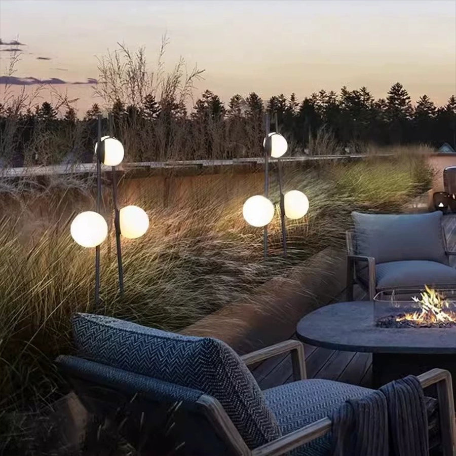 Contemporary outdoor seating area enhanced with stylish sphere lights along wooden deck edge