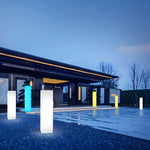Architectural outdoor lighting installation with tall white luminous columns in modern courtyard space