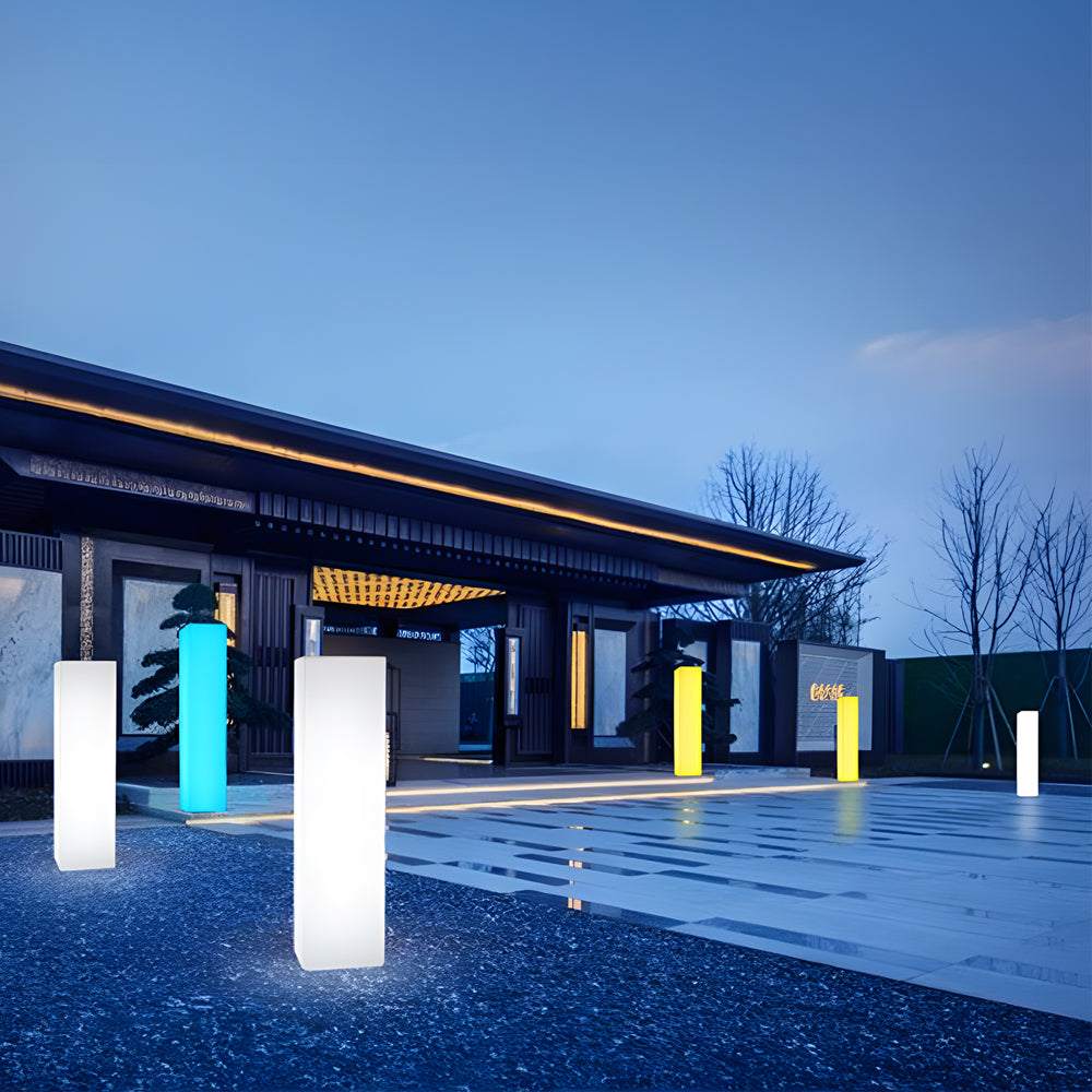 Architectural outdoor lighting installation with tall white luminous columns in modern courtyard space