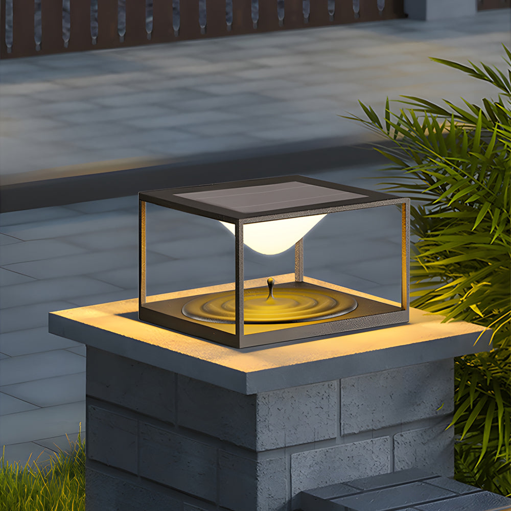 Minimalist cube light fixture positioned on stone pedestal creating dramatic evening landscape lighting