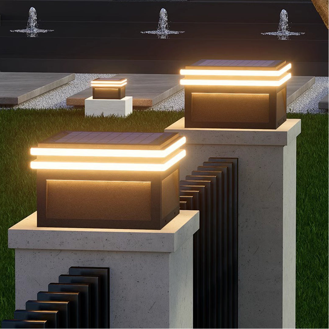Modern cube post lights illuminating contemporary residential patio area with warm ambient lighting at evening