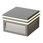 Sleek cube-shaped exterior lighting fixtures with warm LED glow installed along modern commercial building entrance