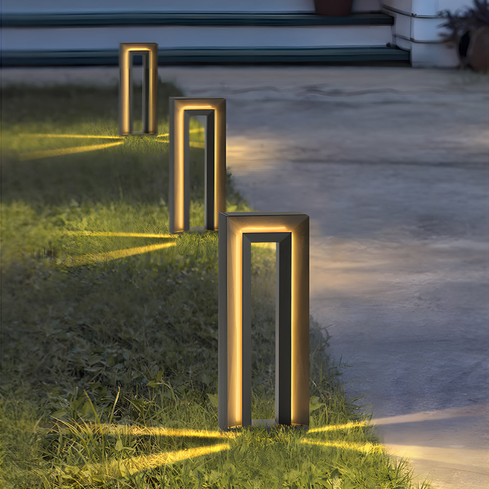 Multiple height bollard lights arranged along curved walkway in residential garden setting