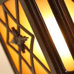 Decorative lantern casting dramatic geometric shadows through latticed glass panels at sunset