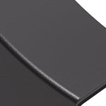 Contemporary black wall light illuminating textured stone surface with dramatic shadows