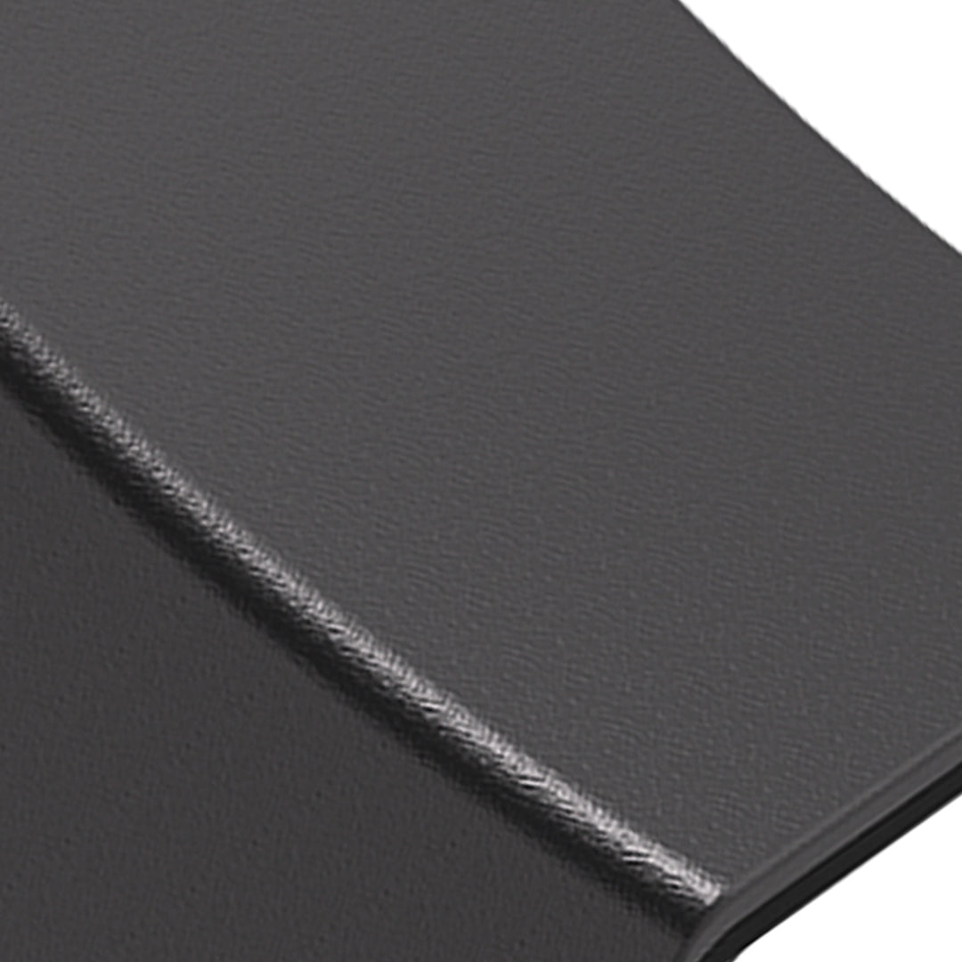 Contemporary black wall light illuminating textured stone surface with dramatic shadows