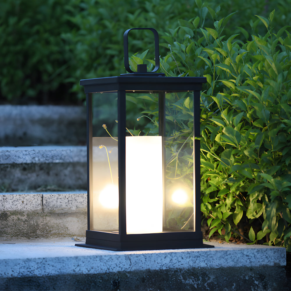 Decorative lantern with flickering LED candle positioned on garden ledge among green foliage