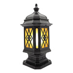 Elegant pillar lantern with detailed metalwork and warm amber lighting on neutral background
