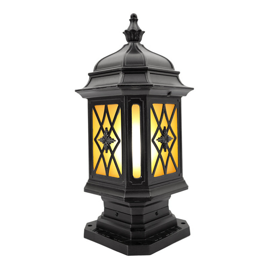 Elegant pillar lantern with detailed metalwork and warm amber lighting on neutral background