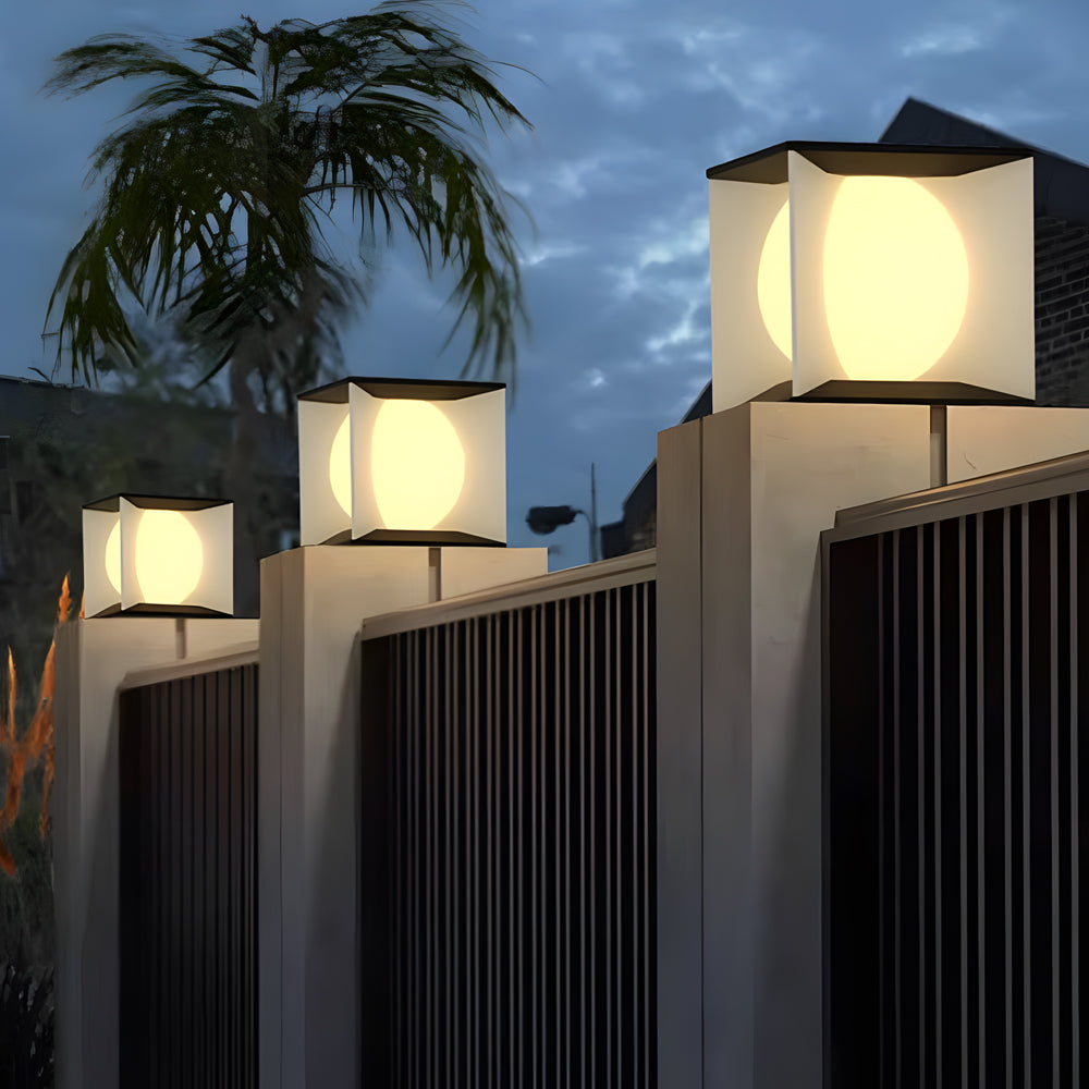 Multiple solar cube lights mounted on fence posts creating uniform pathway lighting