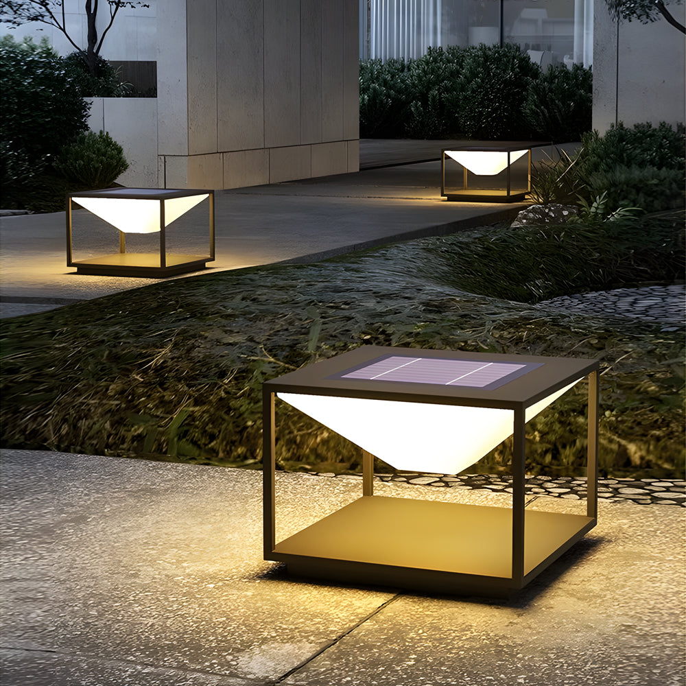 Illuminated cube lights placed in landscaped garden setting with plants and stone pathway