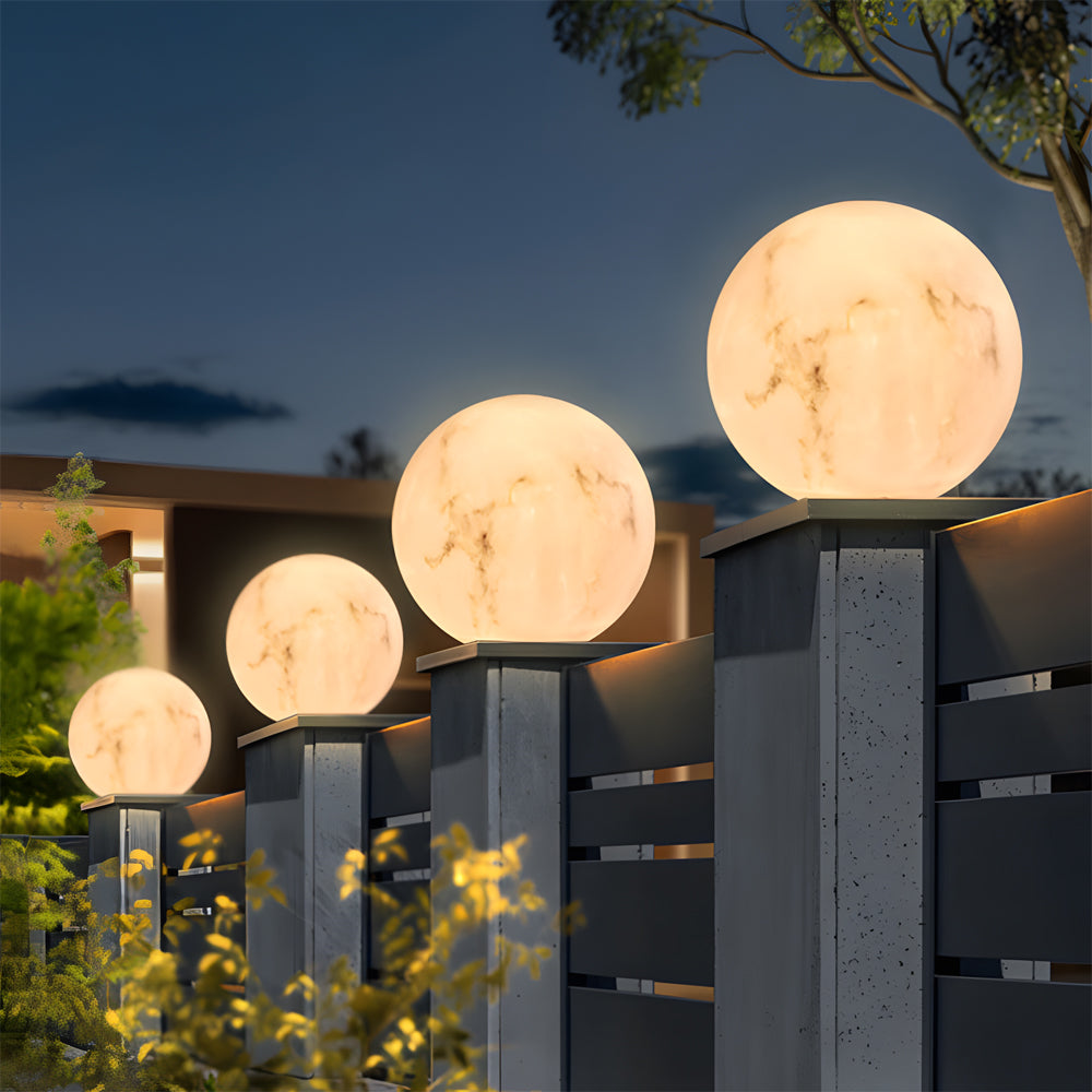 Garden pathway lined with various sized illuminated moon spheres on modern posts