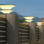 Series of geometric post lights creating uniform illumination along modern concrete walkway