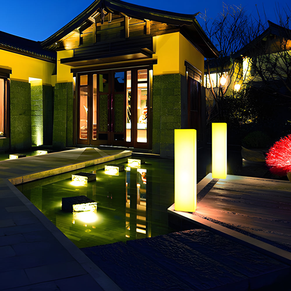 Elegant illuminated pillars enhancing contemporary home exterior with warm ambient glow at dusk