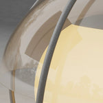 Close-up detail of illuminated sphere light showing warm LED glow and metal frame construction