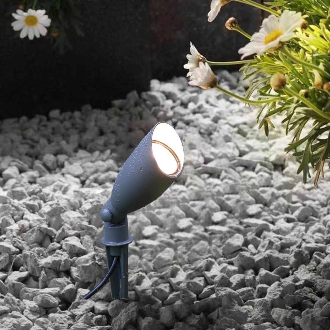 Landscape spotlight positioned in green lawn creating directional lighting for garden accent illumination