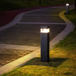 Architectural square bollards illuminating landscaped plaza area with contemporary design