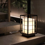 Single lantern light fixture on modern outdoor deck with architectural background