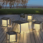 Multiple LED cube lights scattered on wooden deck creating magical twilight ambiance near water