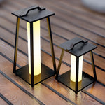 Multiple LED lanterns with handles arranged on wooden deck creating cozy evening atmosphere