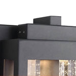 Pair of matching wall sconces flanking residential entrance with evening illumination