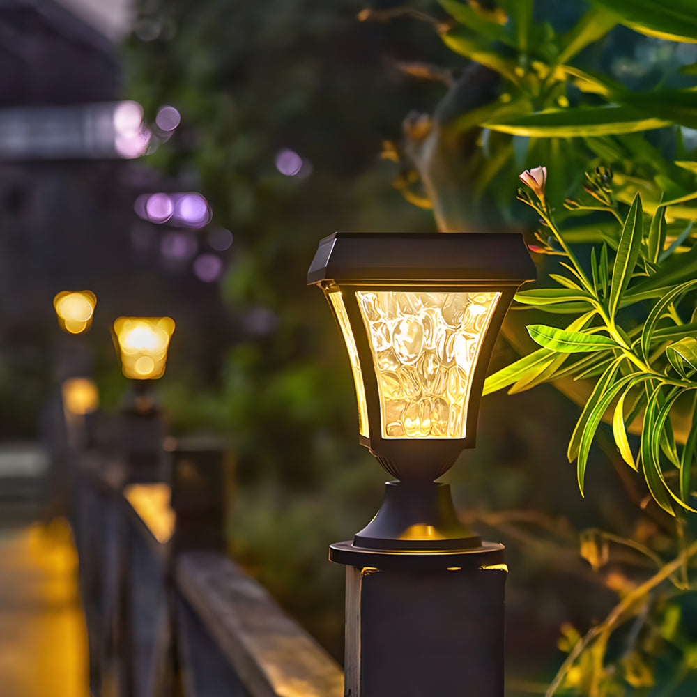Elegant post lantern with warm LED lighting creating cozy atmosphere among lush garden plants