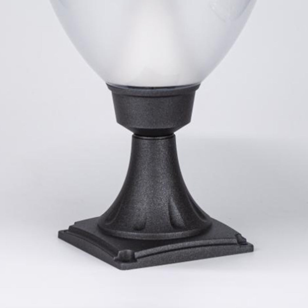 Bowl-style bollard light creating warm ground illumination in residential garden setting