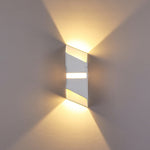 Sleek wall light with silver and gold elements producing geometric light patterns