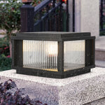 Modern solar deck light with ribbed glass panels installed on white concrete surface
