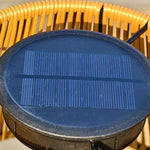 Close-up view of circular solar panel integrated into top of rattan lampshade for renewable energy