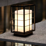 Square lantern light with grid pattern placed on stone surface creating ambient outdoor lighting