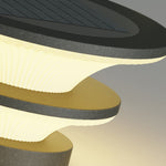 Modern stacked disc pendant lights with alternating dark and light circular layers creating sculptural lighting design
