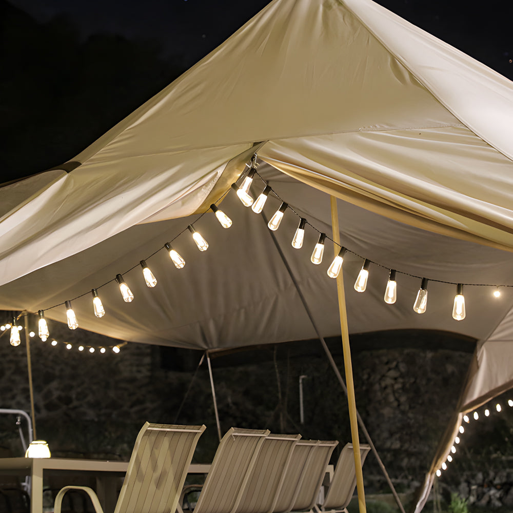Outdoor party tent decorated with festive string lights creating cozy evening ambiance