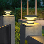 Modern tiered post cap lights creating dramatic upward illumination on concrete pillars at twilight